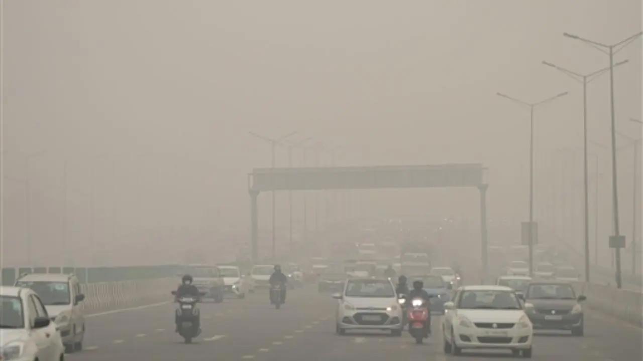 नई दिल्ली में कोहरे से ढकी सड़क पर यात्री (फोटो: पीटीआई)