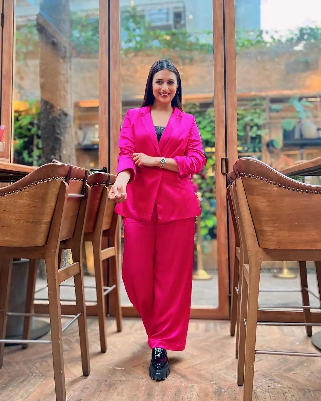 अपने पहनावे में बॉस लेडी का माहौल जोड़ने के लिए दिव्यांका ने अपने गुलाबी फॉर्मल्स को काले जूतों के साथ जोड़ा.