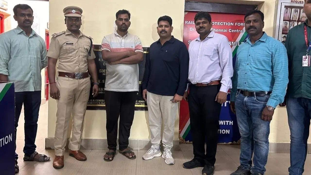 आरोपी (सफेद टी-शर्ट में) अधिकारियों की टीम के साथ जिसने उसे पकड़ा
