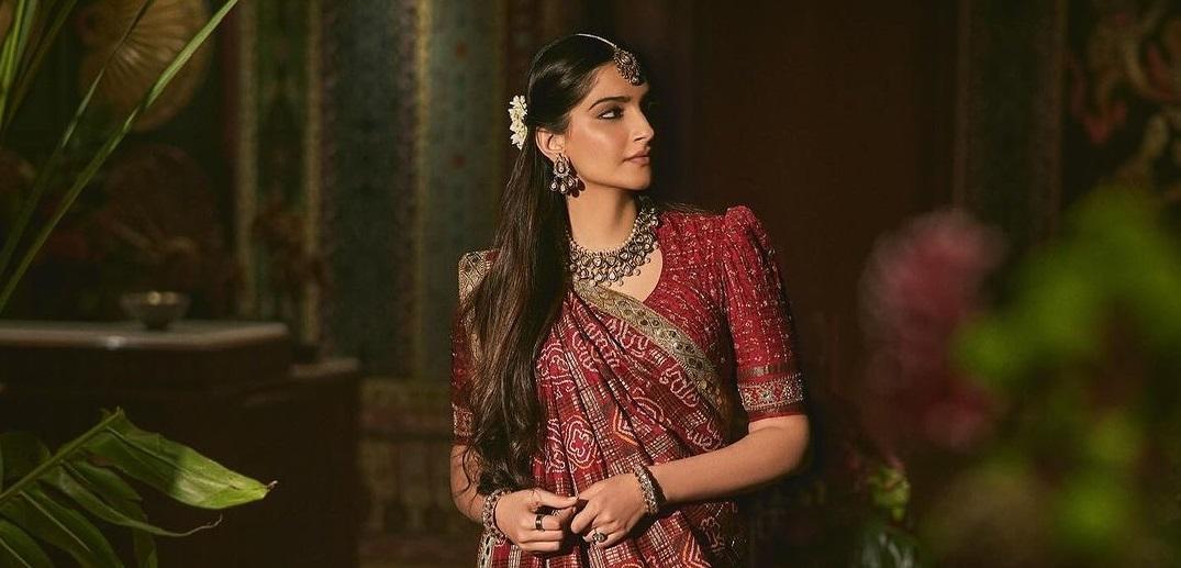लाल गुजराती साड़ी में सोनम कपूर का ये लुक खूब वायरल हो रहा है. एक्ट्रेस ने तस्वीरें सोशल मीडिया पर शेयर की हैं. इसके साथ ही कैप्शन में लिखा है कि ये साड़ी किसकी है और कहां से आई?
