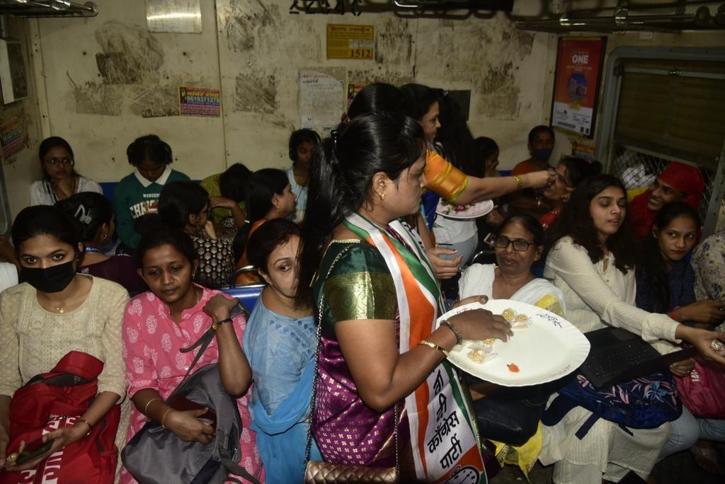 महिला यात्रियों को तिल-गुड़ बांटती महिला आयोग की कार्यकर्ताएं.