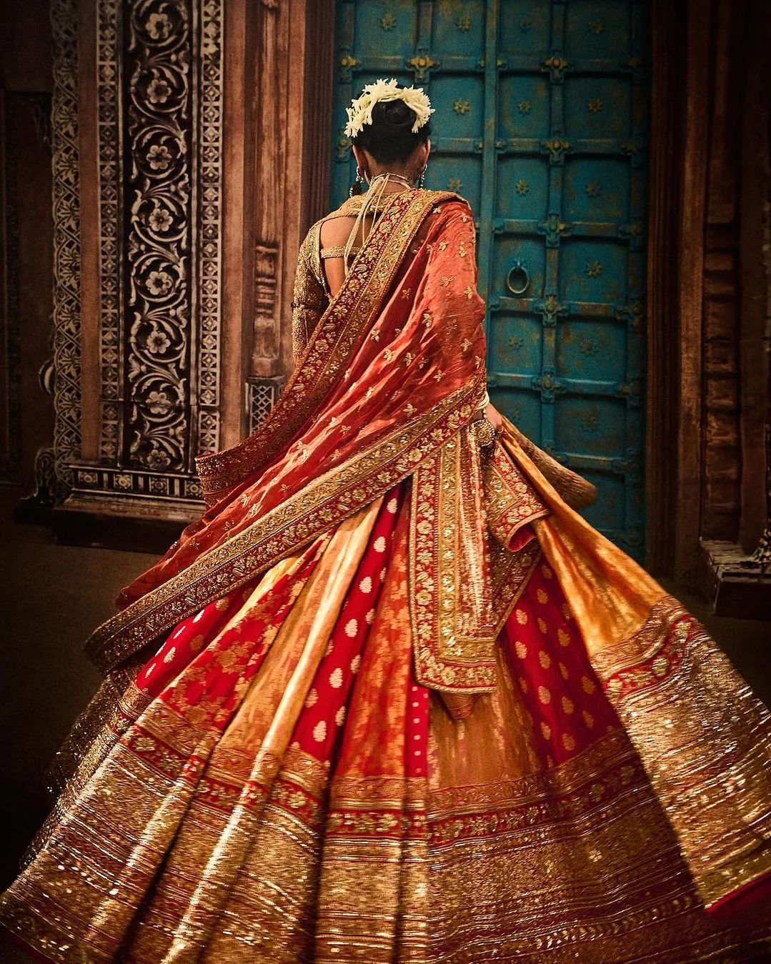राधिका के इस सिंदूरी लाल लहंगे को उन्होंने डिजाइनर गोल्डन ब्लाउज के साथ कैरी किया था. एक बैकलेस ब्लाउज़ शामिल था, जिस पर असली सोने के करचोबी काम से सजावट की गई थी.