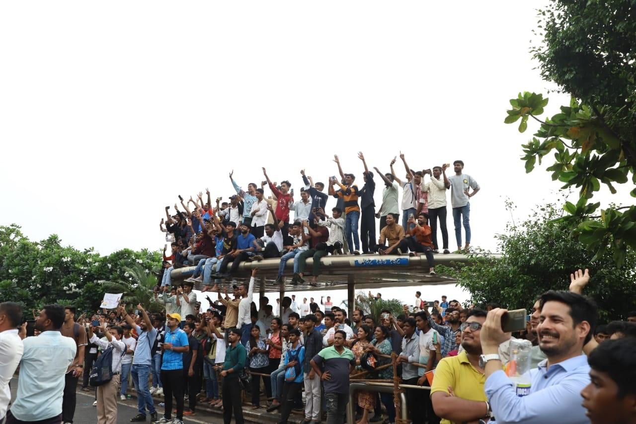 इस दौरान कुछ प्रशंसक कारों, पेड़ों और रास्ते में खाने-पीने की दुकानों की छतों पर चढ़े हुए नजर आए.