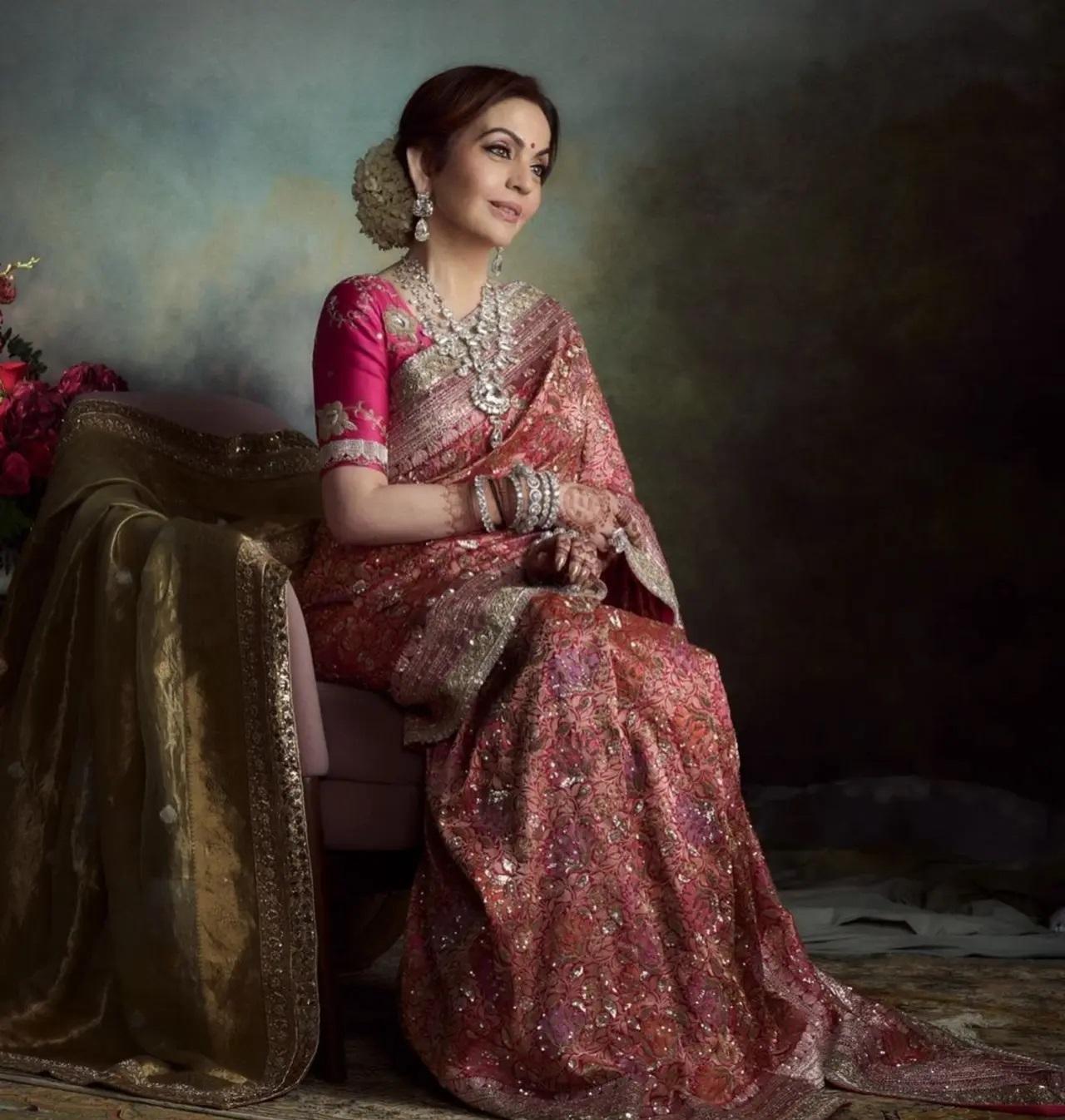 शादी के रिसेप्शन के लिए, नीता ने मनीष मल्होत्रा ​​द्वारा डिज़ाइन की गई एक कस्टम पिंक मल्टी-रेशम कढ़वा फ्लोरल वोवन ब्रोकेड साड़ी पहनी थी. साड़ी को जटिल असली चांदी की कढ़ाई से सजाया गया था. 