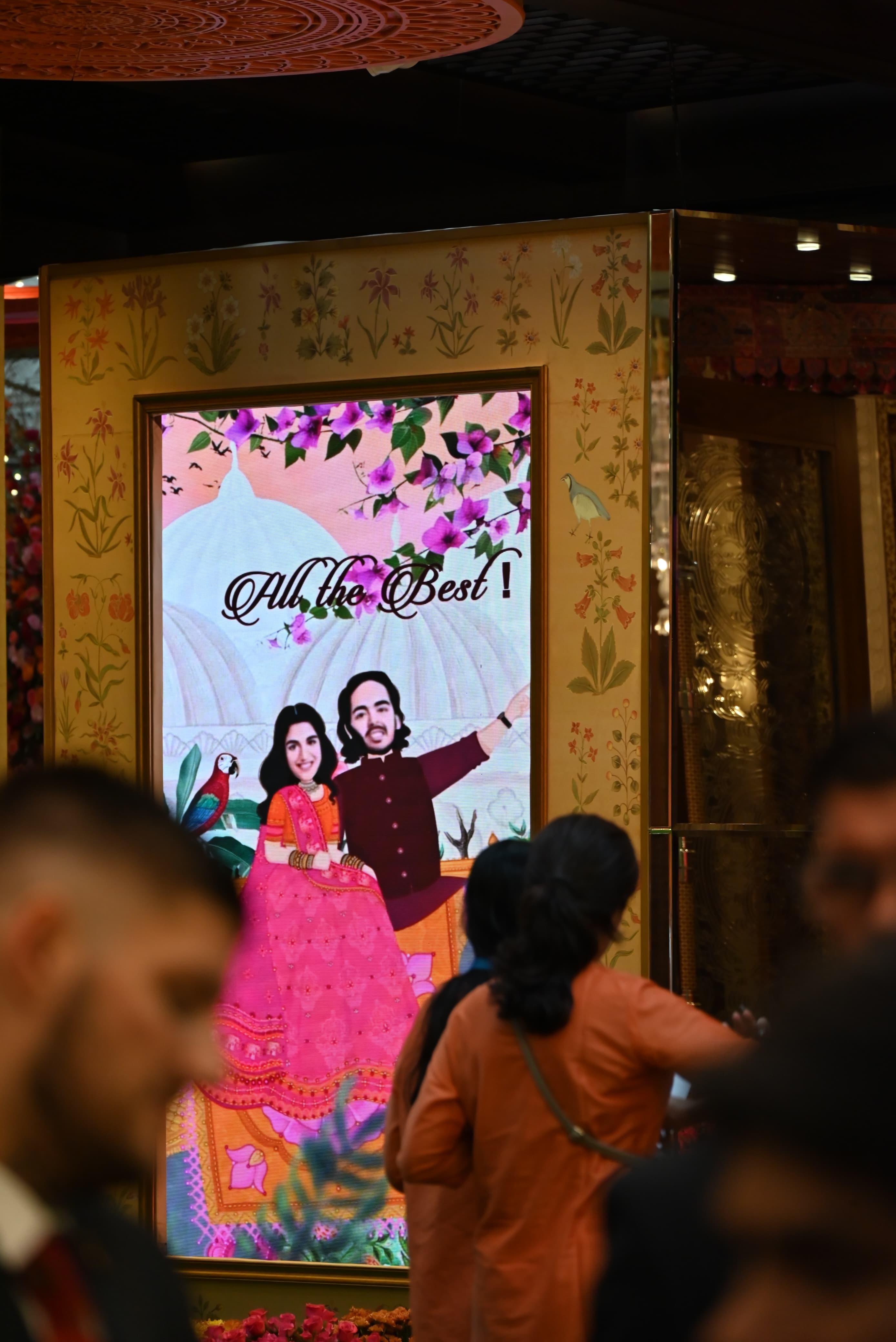 अनंत अंबानी और राधिका के कार्टून पोस्टर भी ऑरेंज शेड में लगाए गए, इसमें ऑल द बेस्ट लिखा हुआ था.