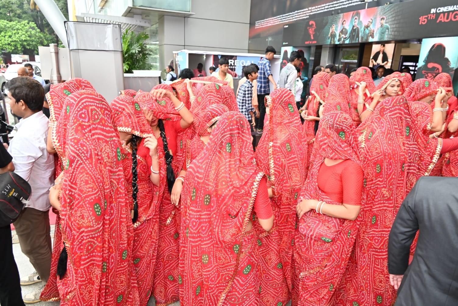ट्रेलर लांच के दौरान बहुत सारी महिलाएं लाल बांधनी साड़ी में लंबी चोटी के साथ दिखाई दीं.
