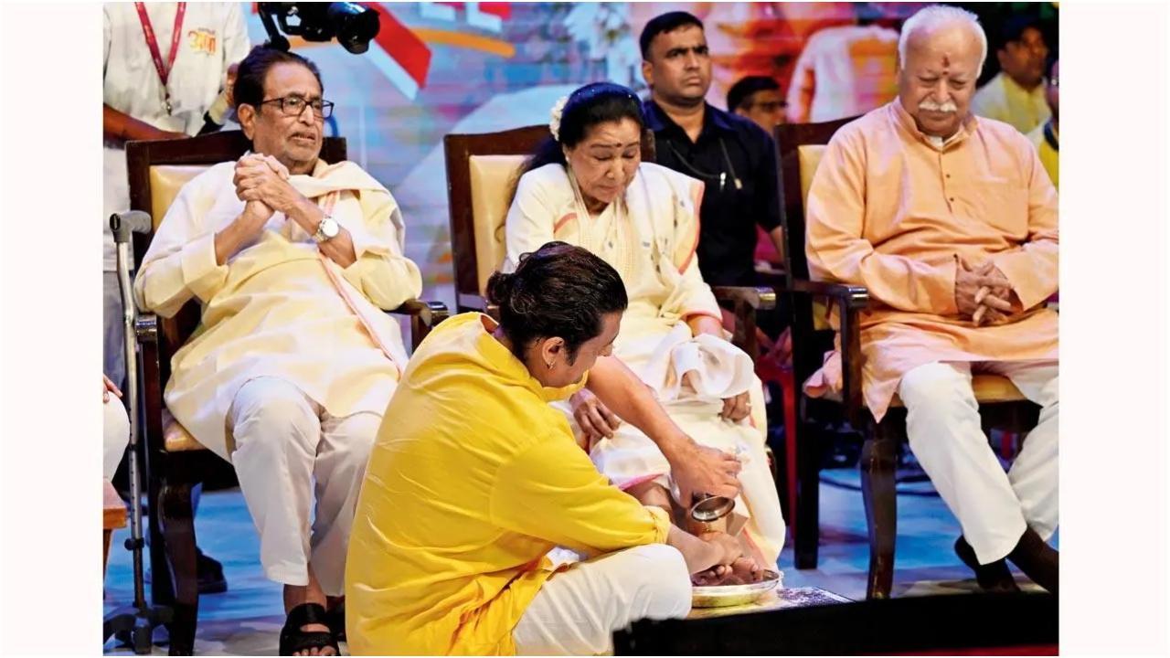 पंडित हृदयनाथ मंगेशकर, आशा भोसले और मोहन भागवत सोनू निगम द्वारा भोसले के पैर धोए जाने को देखते हुए