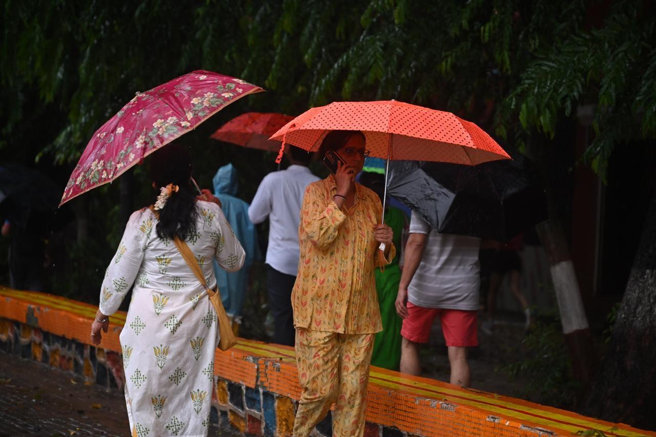 बारिश के दौरान ठंडे मौसम और हरियाली का आनंद लेती महिलाएं.