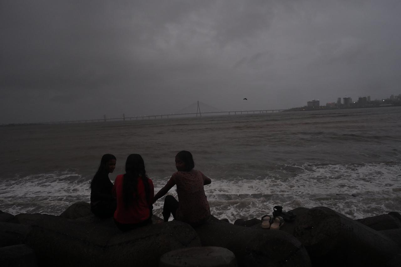 समुद्र के किनारे बारिश के दौरान मौसम का आनंद लेते मुंबईकर.