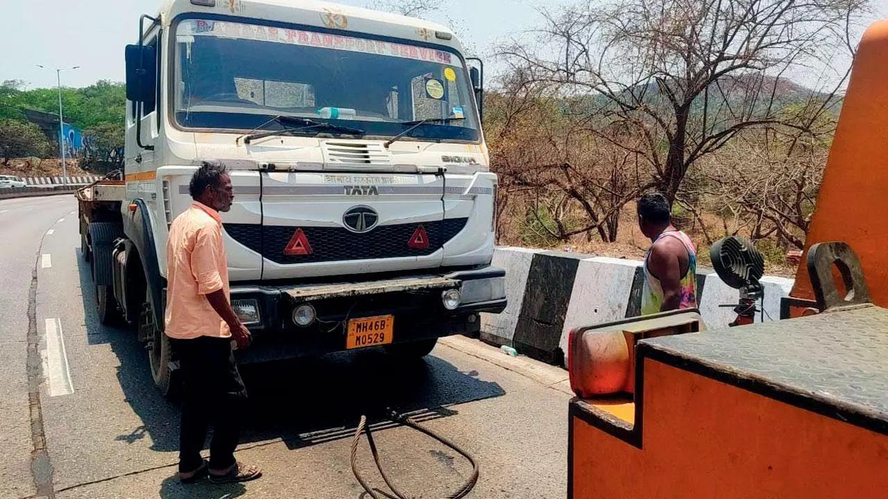एक्सप्रेसवे पर एक ट्रक खराब हो जाने के बाद उसे हटाया जा रहा है