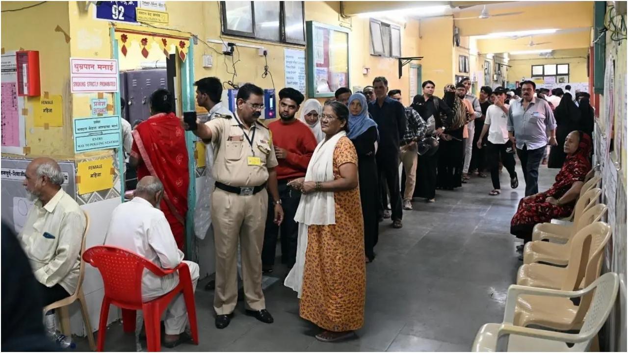 बुधवार को मानखुर्द शिवाजीनगर निर्वाचन क्षेत्र में एक मतदान केंद्र पर एक पुलिसकर्मी एक मतदाता को मार्गदर्शन करता हुआ. तस्वीर/सैय्यद समीर अबेदीदीपिक/सैय्यद समीर अबेदी