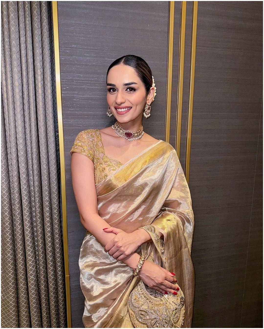 चैनलिंग इनर क्वीन इन ए टिशू साड़ी
मानुषी छिल्लर ने गोल्डन टिशू साड़ी में शाही अंदाज दिखाया और इसे भारी डिटेल वाली पोटली के साथ पेयर किया. अपने ट्रेडिशनल वियर को और भी बेहतर बनाने के लिए, एक्ट्रेस ने खुद को स्टेटमेंट ज्वेलरी पीस और गजरे के साथ सजाया. 
