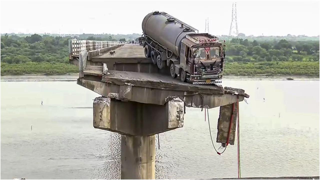 गुजरात के वडोदरा ज़िले में गुरुवार को चार दशक पुराने एक पुल का एक हिस्सा ढह जाने से कई वाहन महिसागर नदी में गिर गए. तस्वीर/पीटीआई
