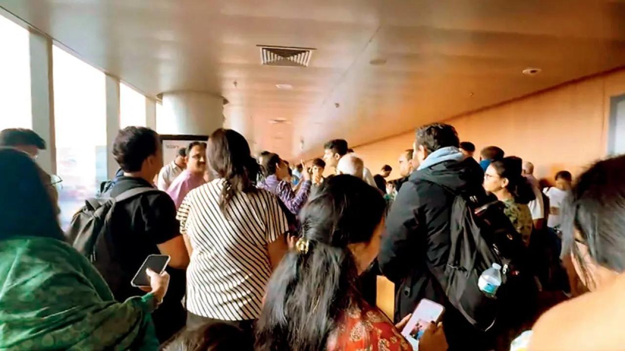 इंडिगो की विलंबित उड़ान से उतरने के बाद यात्री मुंबई हवाई अड्डे के टर्मिनल 2 पर इंतजार कर रहे हैं.
