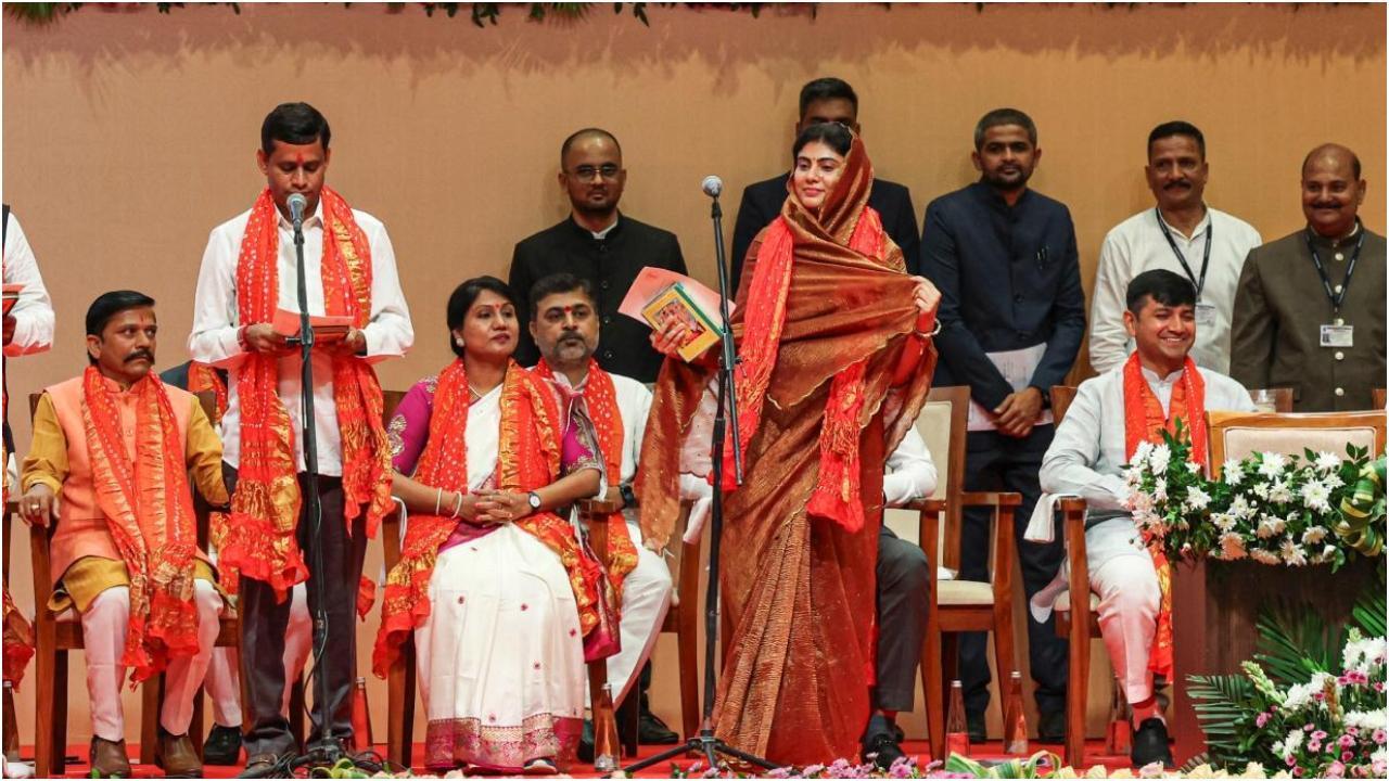 क्रिकेटर रवींद्र जडेजा की पत्नी विधायक रीवाबा जडेजा गुजरात के गांधीनगर में नए गुजरात मंत्रिमंडल के शपथ ग्रहण समारोह के दौरान शपथ लेती हुईं (फोटो: एजेंसी)
